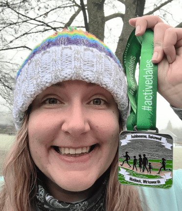 Sam takes a selfie while holding up her #activedales medal.