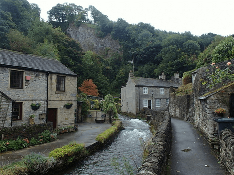 A river runs between the picturesque houses of Castleton.