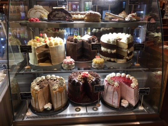 Three tiers of cakes on display at a cafe