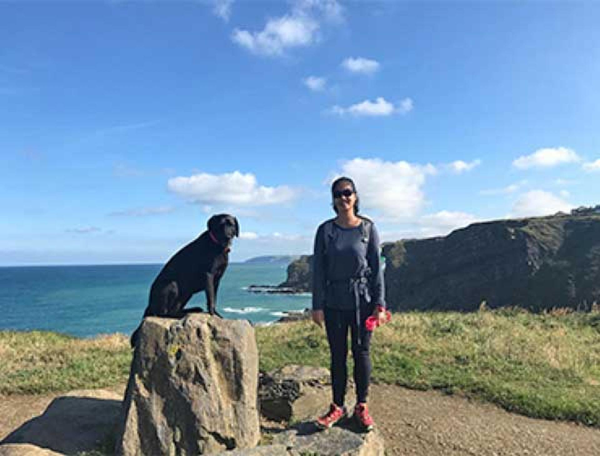 Walker and dog at the coast on their walking holiday