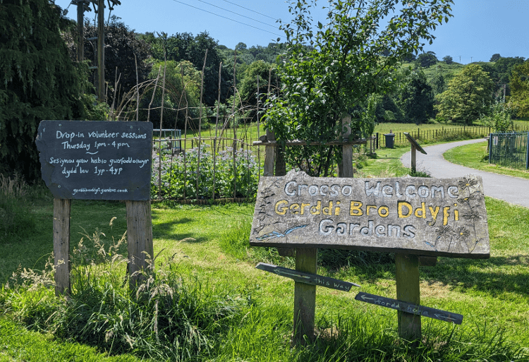 The sign outside Gerddi Bro Ddyfi, including a chalkboard displaying this week's volunteer hours.