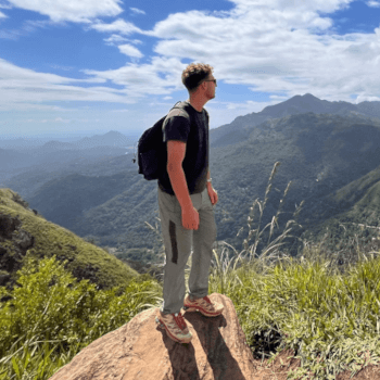 Isaac, research administrator and customer services advisor, out in the mountains on a summer day.