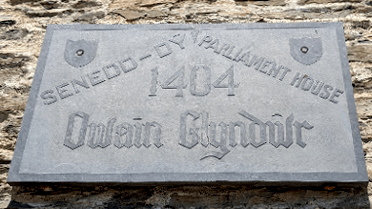 A plaque hung on the wall of the parliament building in Machynlleth.