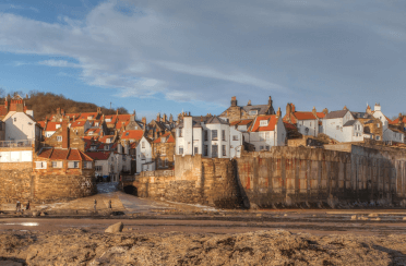 Red brick and white-washed houses cluster above the water at Robin Hood's Bay,