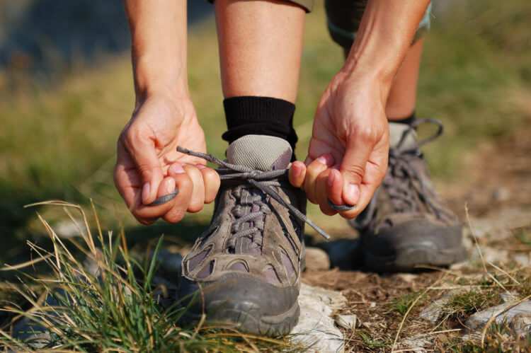 A runner ties shoes built from potentially problematic material