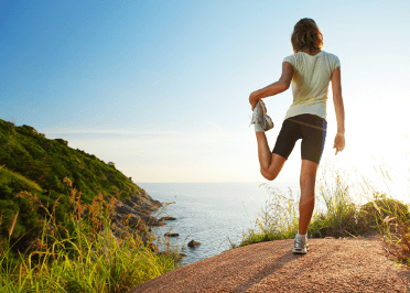 A runner stretches before her trail run to prevent injury.